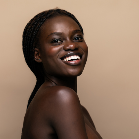 Young african girl with perfect skin on beige background.