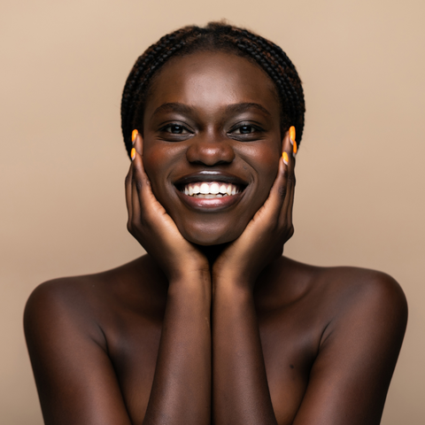 Young african girl with perfect skin on beige background.