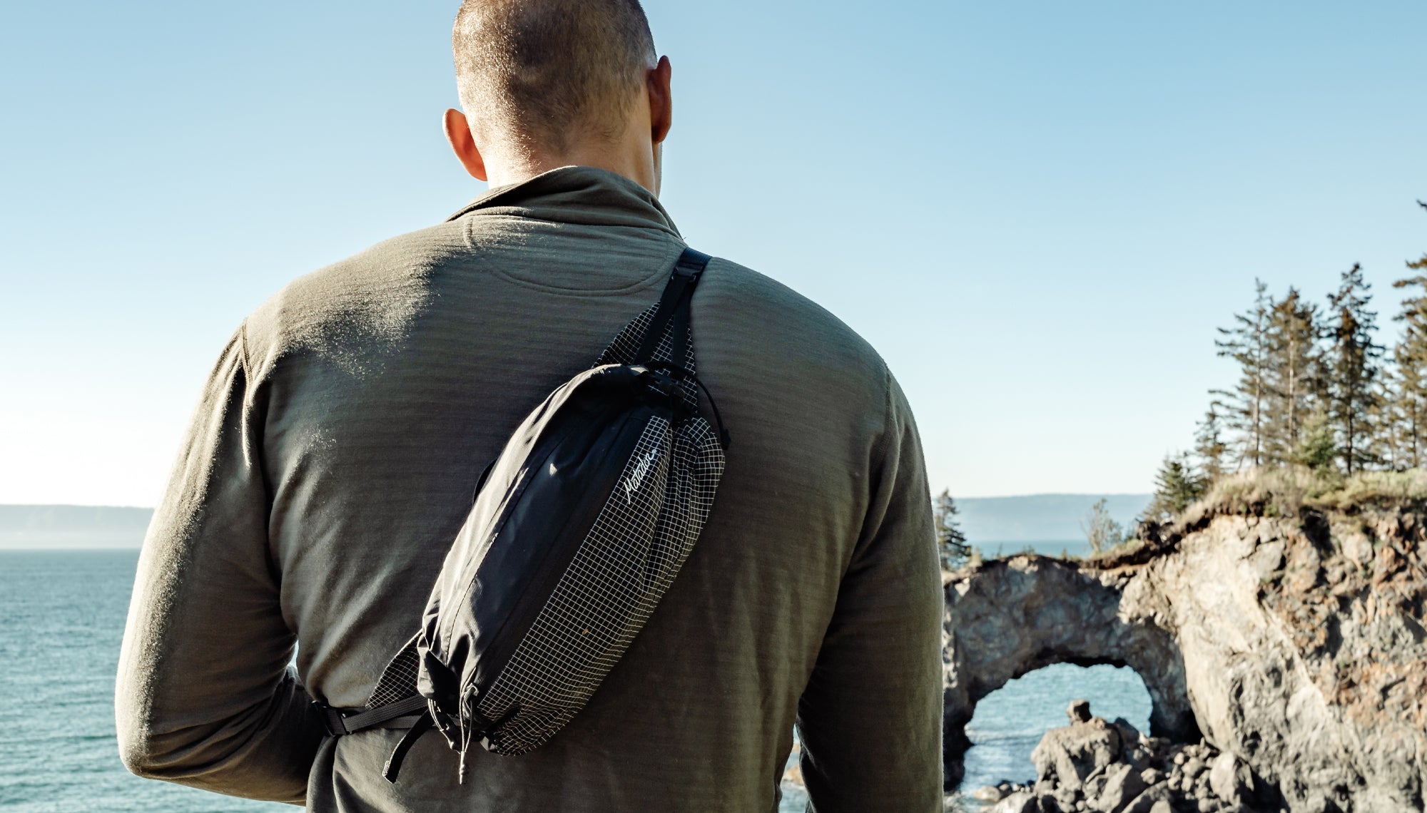 Man looking out at ocean wearing crossbody hip pack