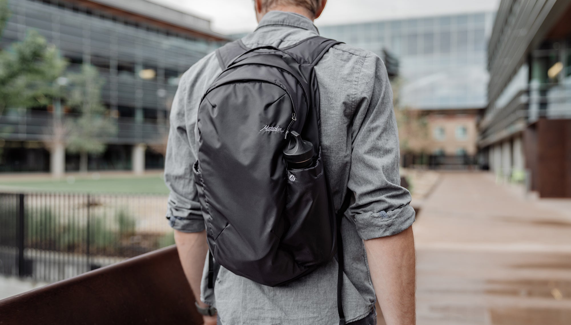 Man walking through city, wearing backpack