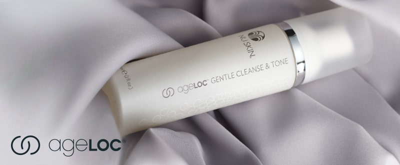 ageLOC Gentle Cleanse & Tone Spender von Nu Skin (60ml) liegt geschlossen auf silbernen Stofflagen.