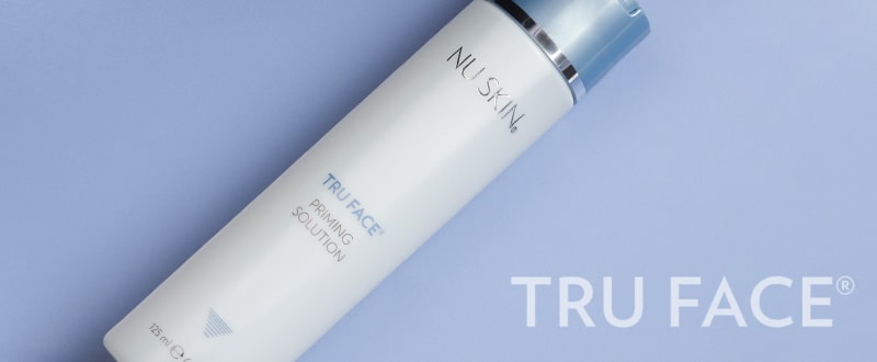 Tru Face Priming Solution Tube (125ml) liegt geschlossen auf glatter blauer Oberfläche.