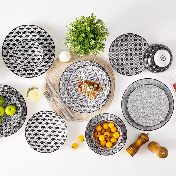 Minimalist Japanese-style dinnerware set with soup bowls on table, accented by fruit and greenery