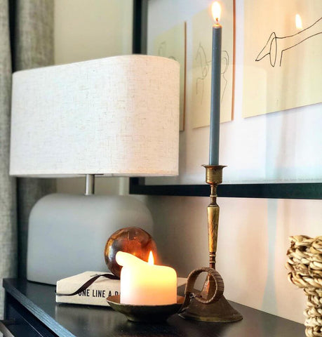 A grey table lamp and candles on a surface image by sharonshomestyle