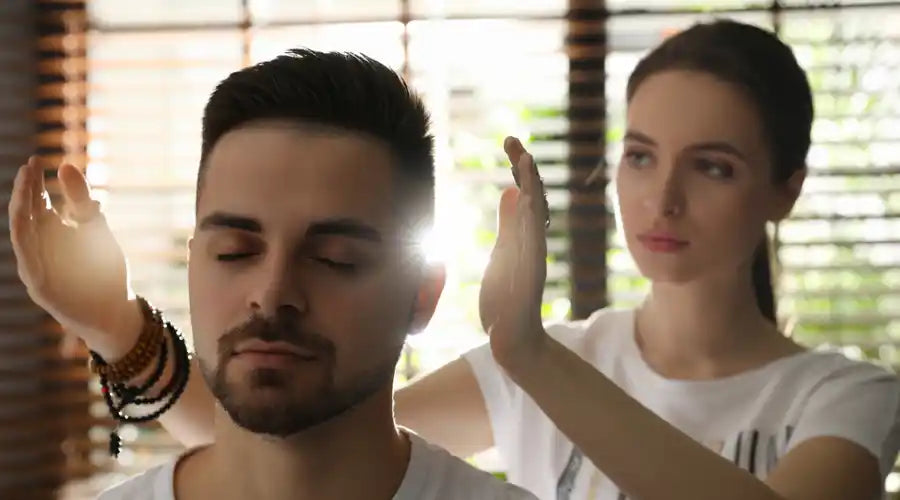 reiki master practitioner giving a man a reiki treatment