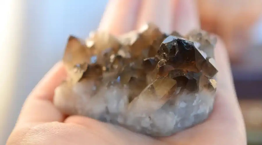 hand holding smokey quartz for energetic protection