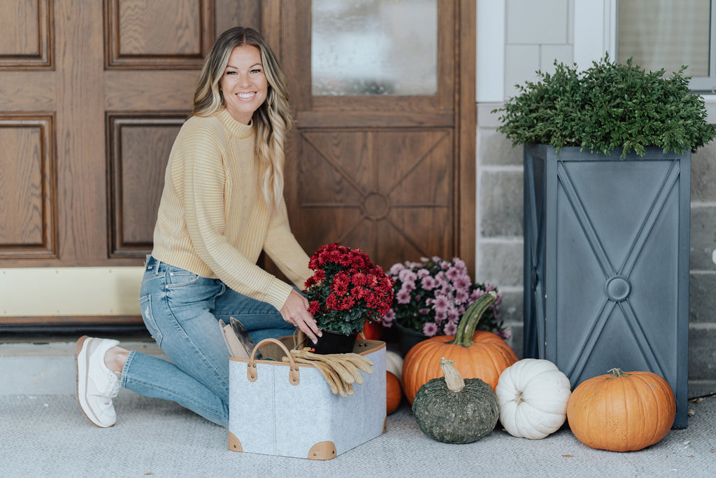 Woman by fall flowers and pumpkins with Salt by Sabrina Taveuni storage basket.