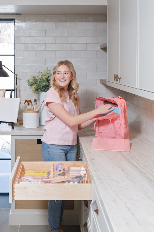 Drawer open with back to school supplies, Girl in laundry room holding back pack getting ready for school, By Salt by Sabrina