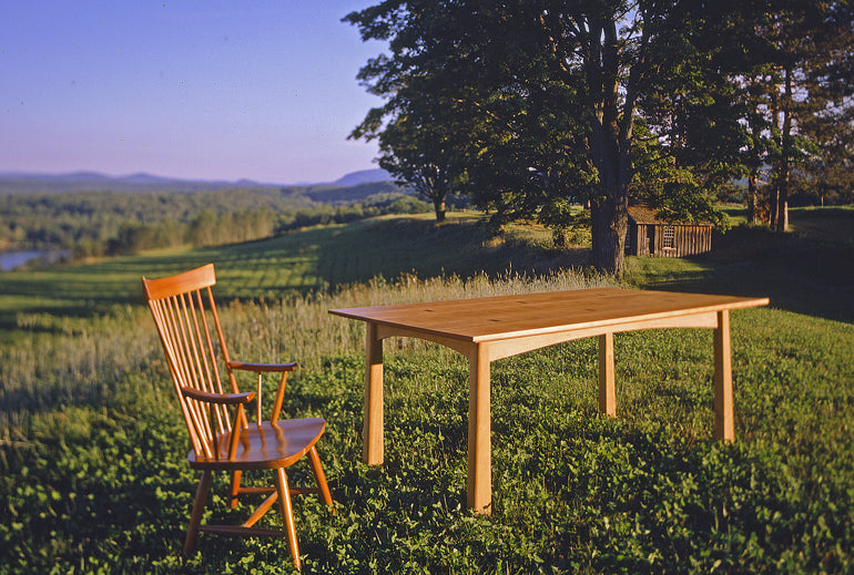 Sustainably crafted wood dining table and chair shot outside on mountain hillside