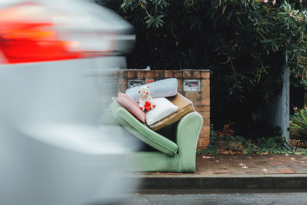 A Green sofa left on a curbside for disposal