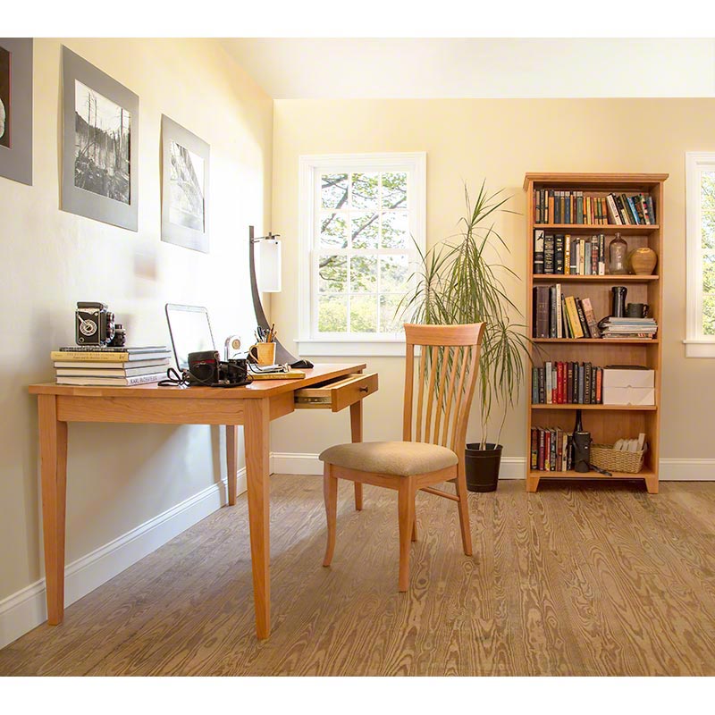 Thuiskantoor met een bureau, boekenkast en plant voor een goed verlicht raam