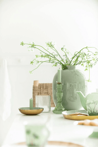 Gedeckter Tisch mit grünen Vase, grüner und goldener Dekoration
