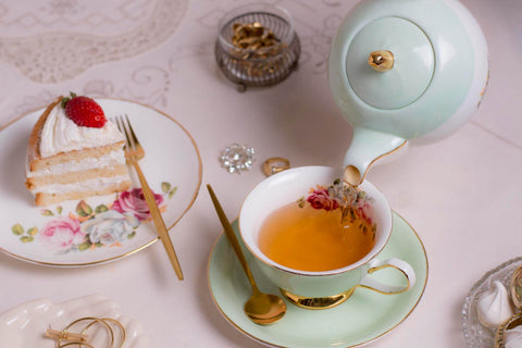 Tasse Tee mit Teekanne und Kuchen
