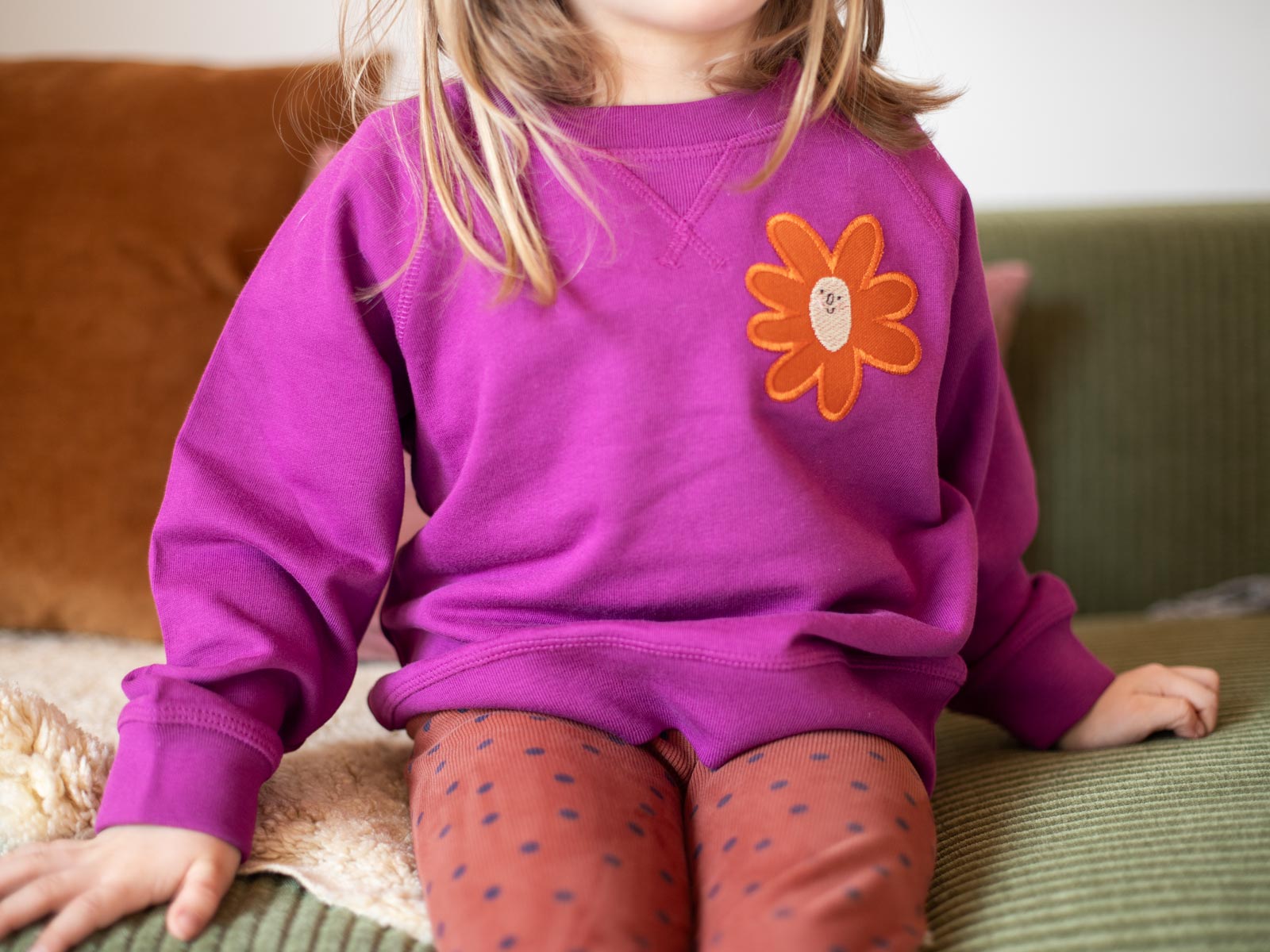 Kind mit Sweater verziert mit Aufnäher "Blume groß" designed von Anna Katharina Jansen von halfbird