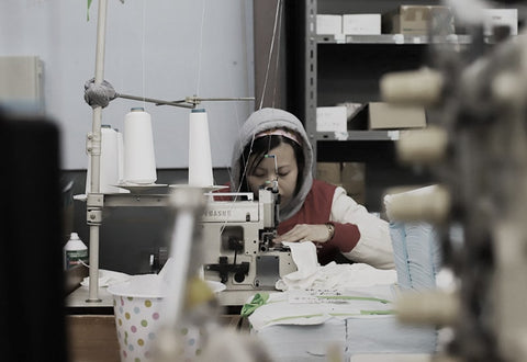 ミシンで縫製する女性