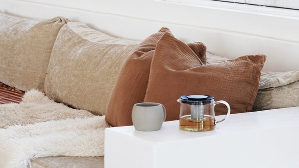 mug and teapot next to comfy couch
