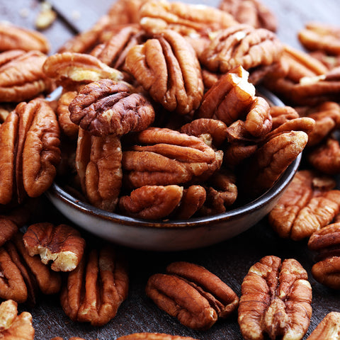 McMillan pecan brown pecans overflowing in a bowl onto a counter