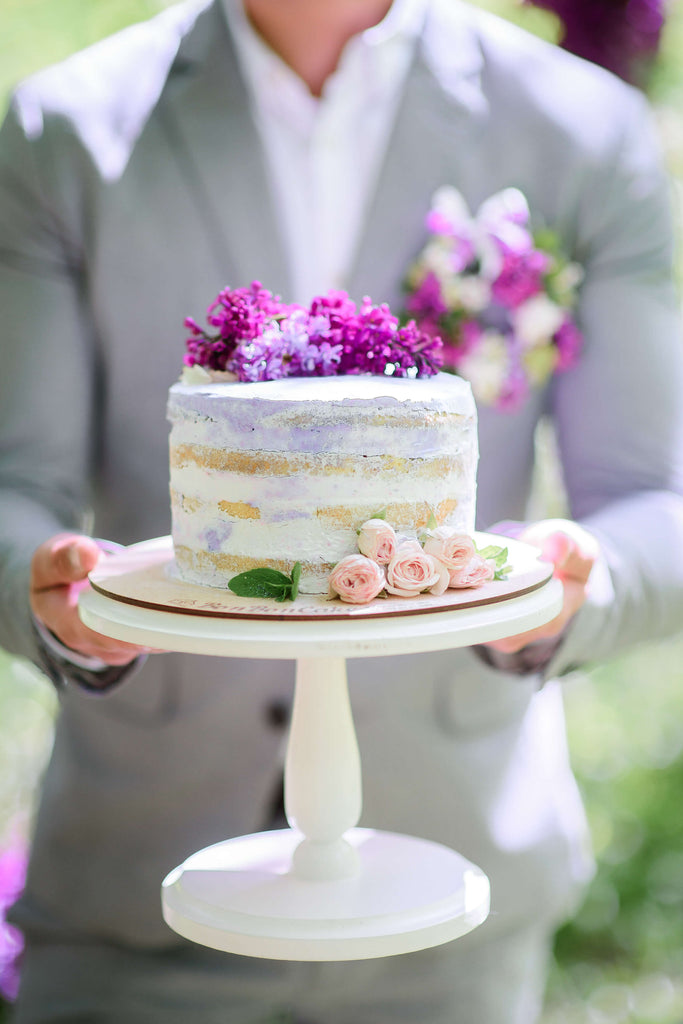 small wedding cake with lilac floral accents and lavender icing