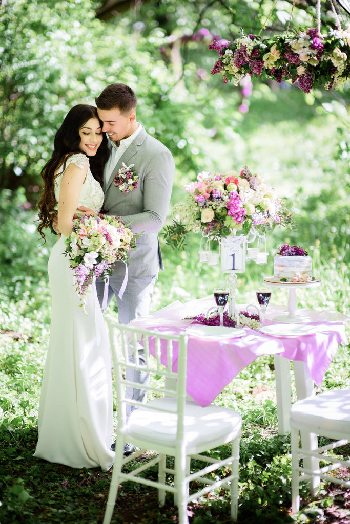 outdoor purple wedding reception and ceremony decor with purple lilac flowers bride and groom