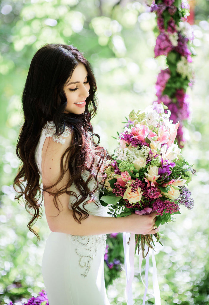 bride holding purple bridal bouquet with lilacs 