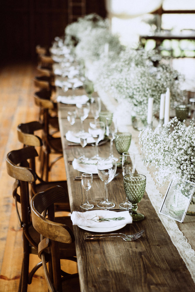 Rustic Chic Wedding in a barn with harvest tables, baby's breath centerpieces and tapered candles in clear bottles