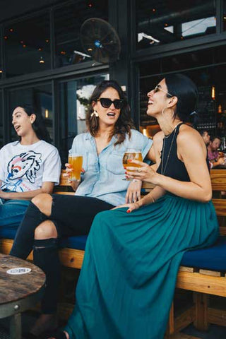 women-sitting-on-bench-restaurant-drinking-after-work-friendship-psyche