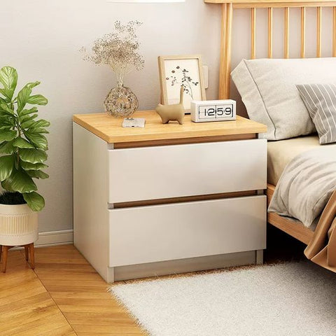 An artificial plant placed besides the side table enhancing the beauty of the bedroom