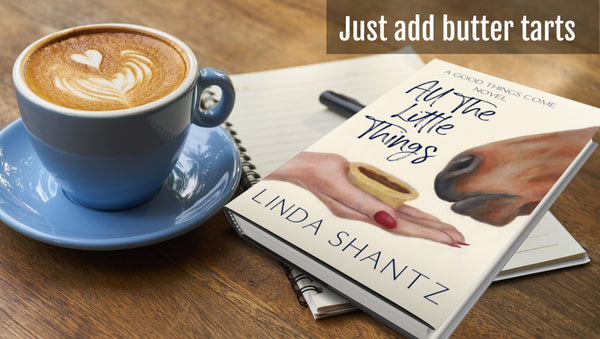 All The Little Things paperback novel by Linda Shantz with coffee cup on table