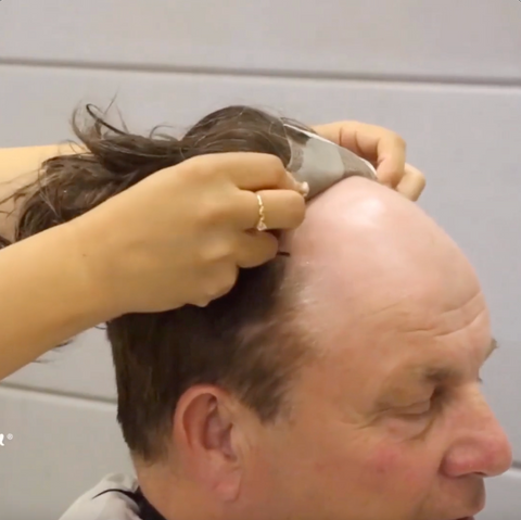 Attaching taped hairpiece to man's head