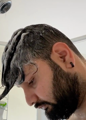 man with shampoo in his hair in the shower