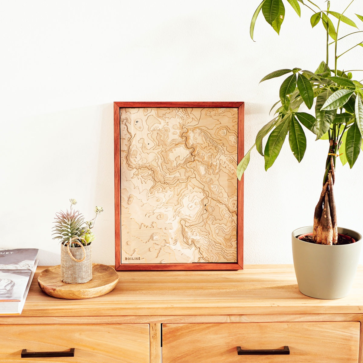 Décoration bois-blanc avec commode, plante et carte topographique du Puy-en-Velay