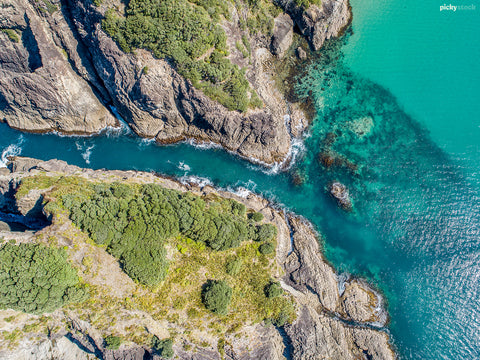 Aerial image of crystal clear waters of rocky coastline. 