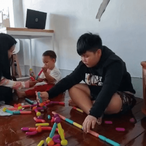 famille qui joue tous ensemble à un jeu de construction magnétique pour tous les âges, la maman et ses fils s'amusent bien