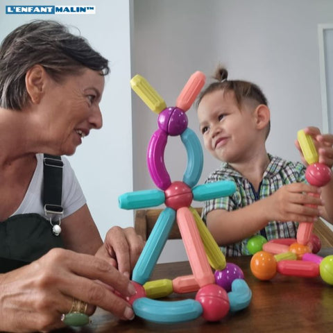 grand-mère et son petit-fils de 3 ans, ils jouent au jeu de construction magnétique, jeu aimanté et s'amuse ensemble