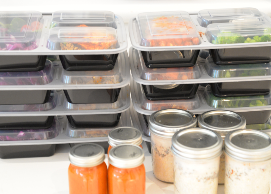 3 section meal containers stacked in a fridge. The containers are holding various vegetable dishes