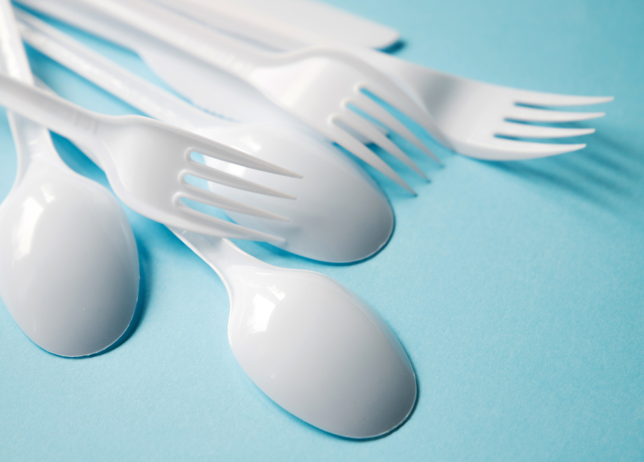 white plastic cutlery on a light blue backgrounf