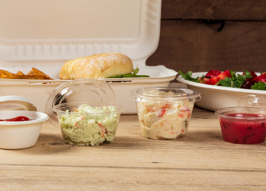 3 clear portion cups. they are holding coleslaw, potato salad, and cranberry sauce. a molded fiber portion cup holding ketchup