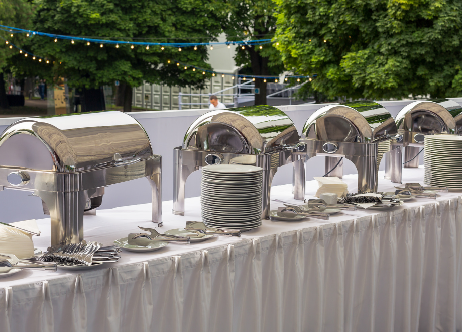 line up of chafing dishes on a buffet table outdoors