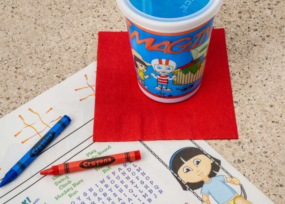 coloring sheet, crayons, and kids cup on a table 