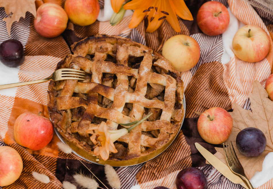 apple pie on a table set with fall decorations