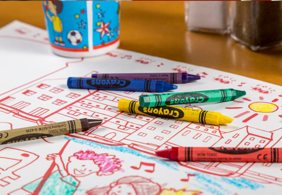 crayons on top of a coloring sheet placemat at a restaurant