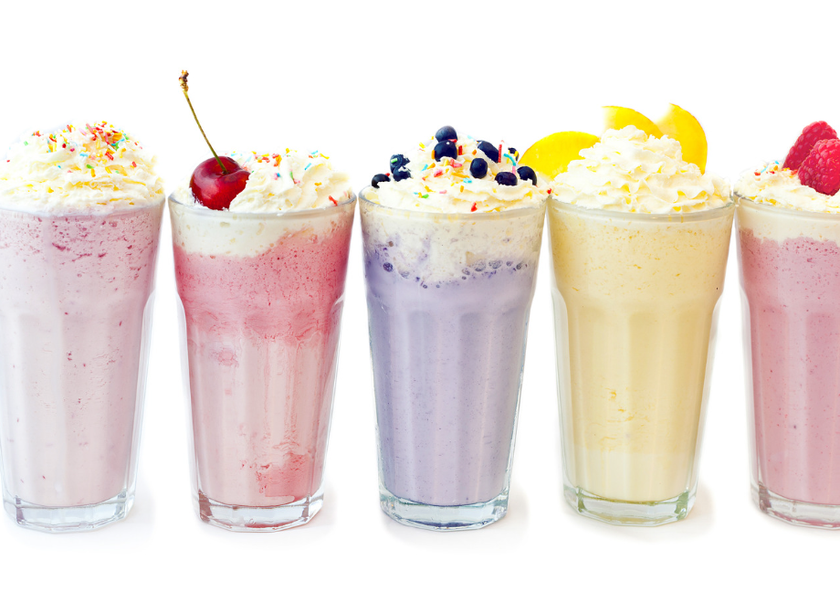 Colorful milkshakes with whip cream and toppings