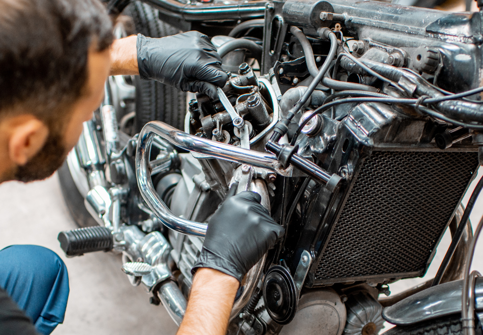 mechanic working on a motorcycle while wearing black nitrile gloves