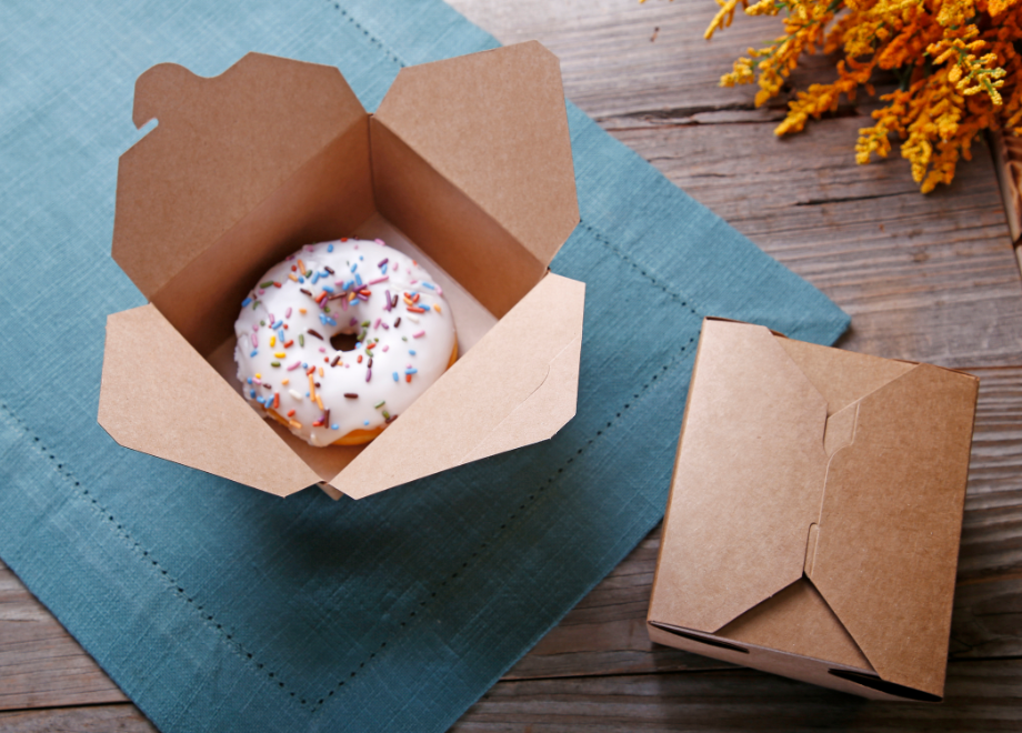 folded takeout box with a white sprinkle donut inside