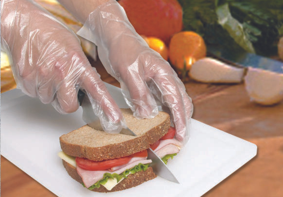 person wearing poly gloves and cutting a sandwich