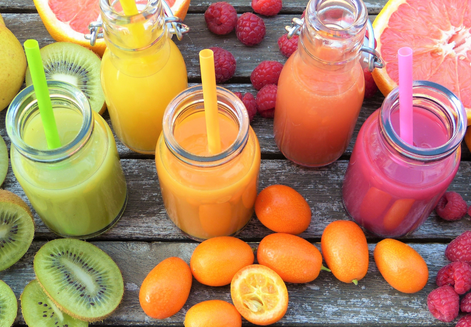 bright fruit smoothies with colorful fruit on the table around them