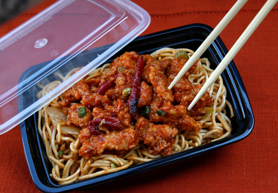 spaghetti in a black plastic takeout container