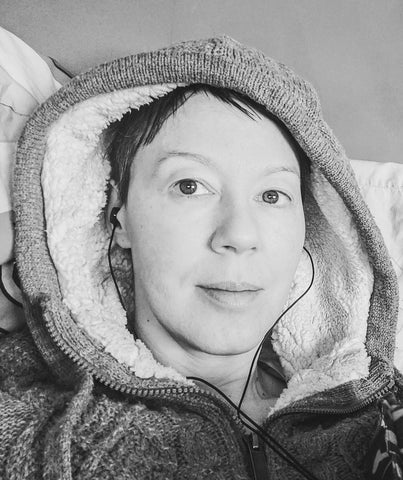 Black and white photo of Yvie in bed looking at the camera.