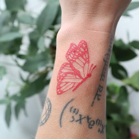 getting a red butterfly tattoo on handTikTok Search