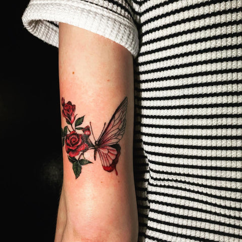 Fine line red butterfly tattoo located on the inner